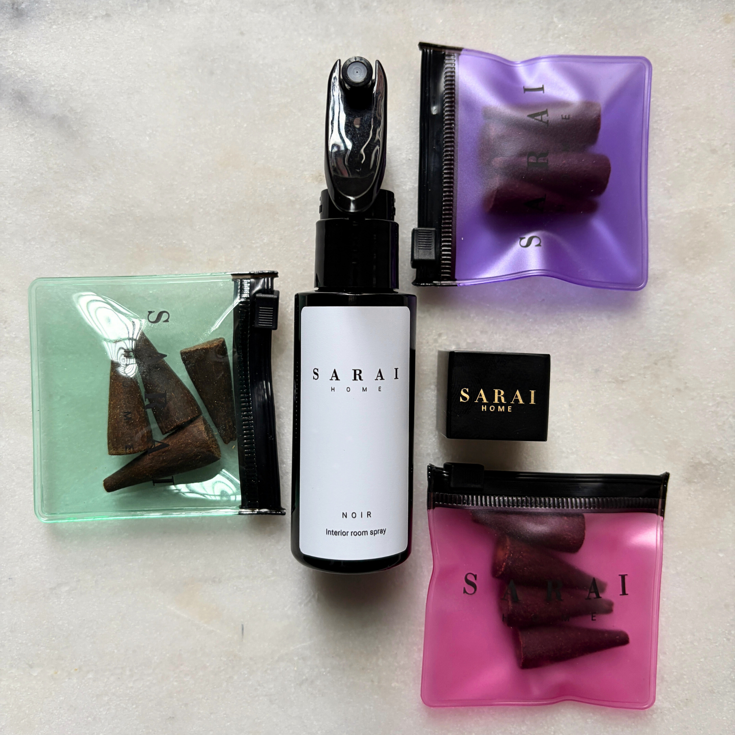 Collection of SARAI home oud fragrance products including an interior spray, incense cones and burner